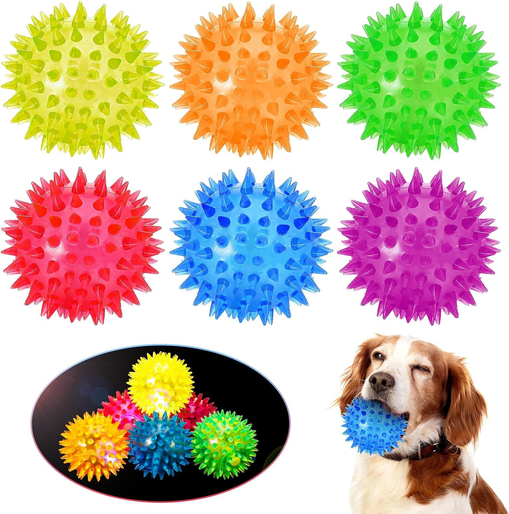 Colorful spiky balls with a dog holding a blue ball.